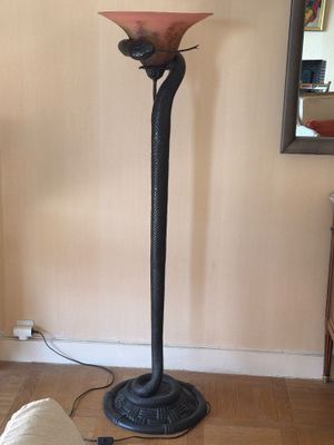 une lampe posée par terre à côté d'un canapé