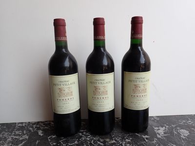 trois bouteilles de vin sont alignées sur une table