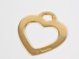 a close up of a gold heart shaped bottle opener on a white surface