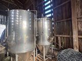two large metal tanks sitting inside of a wooden building