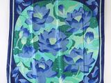 a blue and green floral print scarf hanging on a wall
