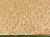 an image of a tan and green leather wallet with a gold clasp