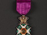 a close up of a medal with a purple ribbon on a black background
