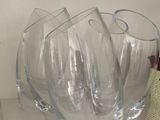 trois verres à vin vides posés sur une étagère à côté d'une bouteille