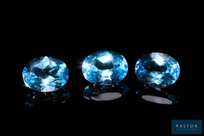 trois pierres précieuses de topaze bleue sur fond noir