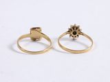 two gold rings with black stones on them on a white surface