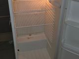 an open refrigerator with a microwave on top of it
