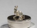 a silver plate with a small animal on it