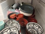 de nombreuses assiettes et bols sur l'étagère du réfrigérateur