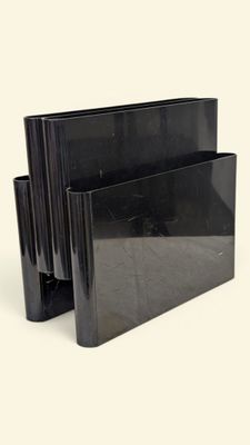 un porte-livre noir posé sur une surface blanche