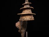 a wooden helmet on a stand against a black background