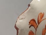 a close up of a vase with orange flowers on it