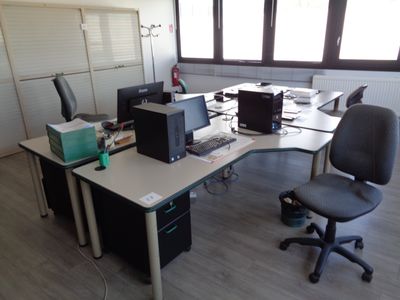 un bureau avec deux ordinateurs et une chaise devant