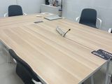 une table en bois entourée de chaises, avec une télévision accrochée au mur