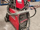 a close up of a red welding machine in a warehouse