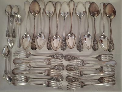 a lot of silver spoons and forks in a white box
