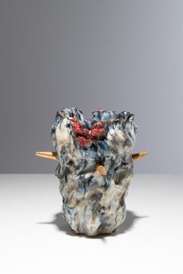un petit vase surmonté d'une fleur rouge