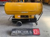 a yellow gas heater sitting on a cart in a garage