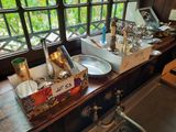 a table with a bunch of silverware on it in front of a window