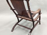 a wooden rocking chair with a brown leather seat and arms