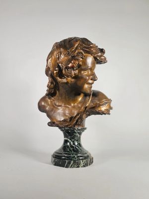 un buste en bronze représentant une femme avec une fleur dans les cheveux