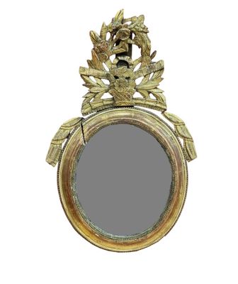 a gold mirror with a bird on it