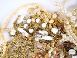 a pile of gold and pearls on a white surface