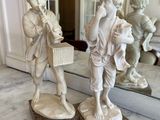 two figurines that are sitting on a marble table