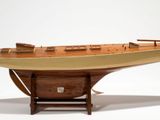 a wooden model of a boat on display on a stand