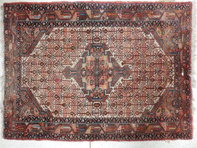 tapis persan antique à motifs géométriques sur fond blanc