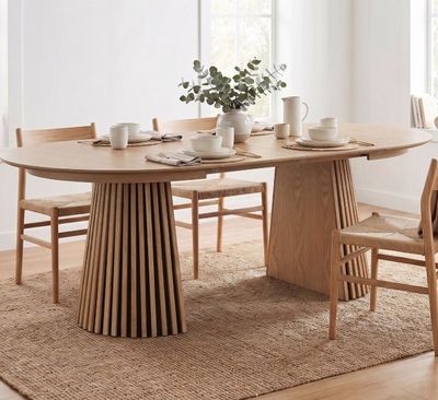 une table en bois avec des chaises et un vase posé dessus