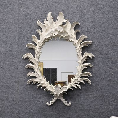 un miroir accroché au mur à côté d'une chaise