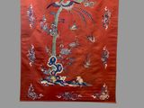 an image of a red wall hanging with a bird on it