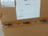 une boîte en carton sur laquelle est accrochée une étiquette de prix, posée par terre