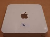 un ordinateur Apple posé sur une table, sur lequel est collé un autocollant