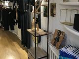 un portemanteau dans un magasin de vêtements, sur lequel sont suspendus des vêtements