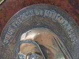 a metal plaque with a picture of a nun on it
