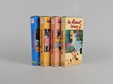 trois livres sont empilés sur une surface blanche
