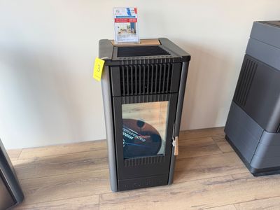 un radiateur noir posé à côté d'un téléviseur, sur un parquet en bois massif