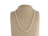a white pearl necklace on a mannequin mannequin