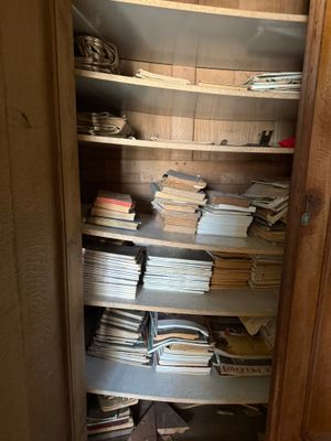 un placard rempli de livres et de papiers, dans un coin de la pièce