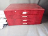 a stack of books sitting on a table next to a red file cabinet