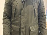 a man wearing a green parka with a fur hood