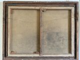 an old wooden frame with a window on top of a table