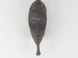 une image d'un masque en bois accroché au mur