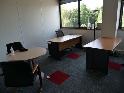 une photo d'un bureau vide avec une table et des chaises