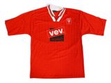 Le t-shirt est rouge et blanc, avec un logo noir et rouge dessus.