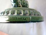 a close up of a green vase with a bird on it