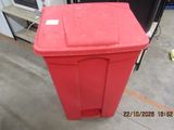 a red trash can that is sitting on the floor