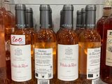 bottles of wine are lined up on a shelf in a store